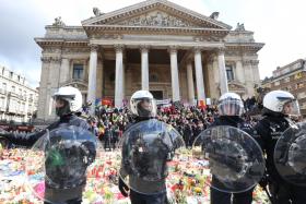WarY: Riot police surrounding the makeshift memorial in tribute to the victims of the Brussels terror attacks last week.