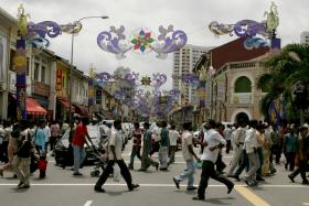 CROWDED: Foreign workers crossing Serangoon Road in Little India. 