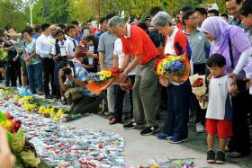 Prime Minister Lee Hsien Loong (in red shirt) and his wife Ho Ching putting flowers at the Garden of Remembrance on March 19 to mark the first anniversary of the passing of Mr Lee Kuan Yew. 