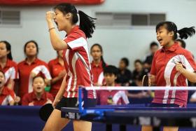 WRAPPING IT UP: Sports School pair Wong Xin Ru (left) and Lew Yen Lin clinch the deciding point in their B Division Girls&#039; final against Raffles Girls&#039; School.