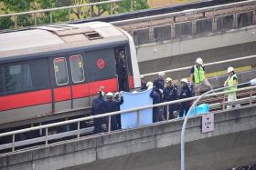 ACCIDENT: Singapore Civil Defence Force officers recovering the bodies of Mr Nasrulhudin Najumudin and Mr Muhammad Asyraf Ahmad Buhari near Pasir Ris MRT station on March 22. Mr Nasrulhudin and Mr Asyraf were undergoing training at SMRT when they died.