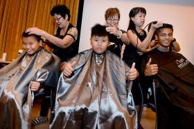 NOBLE CAUSE: (From left) Brothers Alex Chong Kwok Ching and Christopher Chong Kwok Hui, aged 10 and 12, with Abdul Thaslim, 18, at StarHub&#039;s Hair For Hope event.