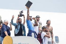 HOMECOMING: LeBron James (in colour) and his Cavaliers teammates return to Cleveland with the NBA trophy in tow.