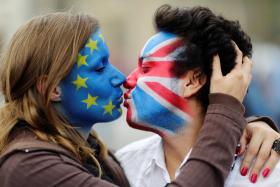 KISS & MAKE UP? Two activists with the EU flag and Union Jack painted on their faces kiss each other, symbolising a preference for the UK to stay in the EU.