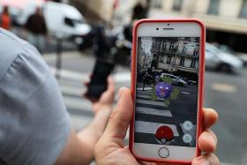 CATCH &#039;EM: This picture taken on Tuesday near the Louvre museum&#039;s pyramide in Paris shows the Pokemon Go app on a smartphone screen.