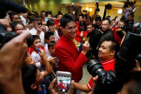  Singapore Olympic gold medallist swimmer Joseph Schooling shows his medal to fans during a homecoming ceremony at Singapore&#039;s Changi Airport 