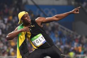 BOLT STRIKES THRICE:  Usain Bolt (right) posing in his &quot;lightning-bolt&quot; pose after winning his third straight Olympics 100m race.