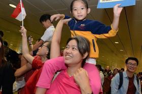 INSPIRED BY JOE: A mother carrying her young daughter on her shoulders to welcome home Singapore&#039;s first Olympic champion Joseph Schooling yesterday.