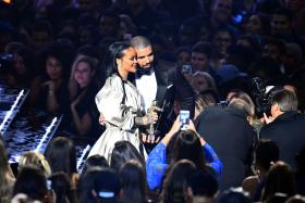 Drake escorts Rihanna after presenting her with The Video Vanguard Award during the 2016 MTV Video Music Awards at the Madison Square Garden in New York on August 28, 2016.