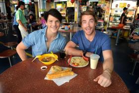 CHOW TIME: Surfing the Menu: Next Generation hosts Dan Churchill (left) and Hayden Quinn enjoying their meal at Toa Payoh West Market &amp; Food Centre.  