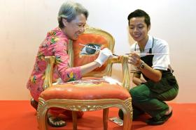 Rainbow Centre student Danial Isaac with Guest of Honour Ms Ho Ching, who is adding final touches to his chair &#039;Heart of Freedom&#039;