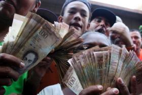 Venezuelans lined up to deposit 100-unit banknotes before they turned worthless, but replacement bills had yet to arrive, increasing the cash chaos in the country with the world&#039;s highest inflation