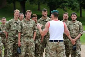 Members of the England national football team are briefed by a British Royal Marine at the Commando Training Centre Royal Marines in Exmouth, Devon.