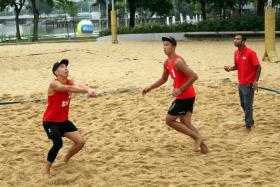 Gilbert Tan setting the ball for Zhuo Hong Chuan in training, as national beach volleyball coach Dean Martin instructs them.