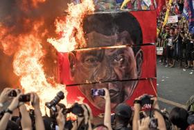 Activists burn an effigy during a protest against Philippine President Rodrigo Duterte near the presidential palace. 