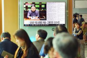 Commuters at a railway station in Seoul watching a television news screen showing
North Korean leader Kim Jong Un delivering a statement in Pyongyang. 