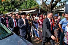 President Joko Widodo waving after getting out of his car. 