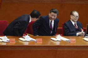Chinese President Xi Jinping (centre) taking a seat between former presidents Jiang Zemin (right) and Hu Jintao. 