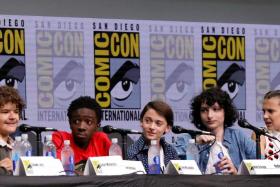 (Seated above, from left) Gaten Matarazzo, Caleb McLaughlin, Noah Schnapp, Finn Wolfhard and Millie Bobby Brown at a panel for Stranger Things at Comic-Con in July. 