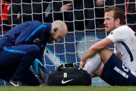 Harry Kane receiving treatment after suffering an ankle injury while playing against Bournemouth.