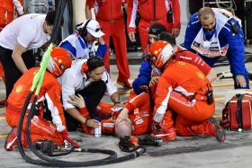 Ferrari&#039;s mechanic is attended by his fellow crew after an accident during the Bahrain Formula One Grand Prix at the Sakhir circuit in Manama.