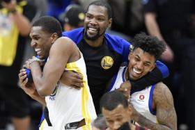 Golden State Warriors forward Kevin Durant (middle) celebrating with forward Kevon Looney (left) and guard Nick Young (right). 