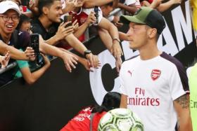 Arsenal's Mesut Oezil received a warm reception at the National Stadium in Singapore although he did not play in the match against Atletico Madrid in the International Champions Cup on Thursday.