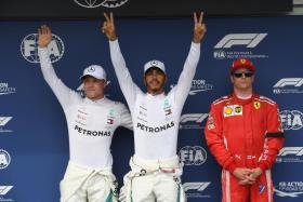 Mercedes&#039; British driver Lewis Hamilton (centre), who took the pole position, celebrates with his teammate Mercedes&#039; Finnish driver Valtteri Bottas, next to Ferrari&#039;s Finnish driver Kimi Raikkonen (right) on the podium after the qualifying session for the Hungary Grand Prix.