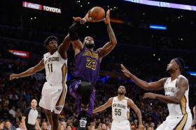 Los Angeles Lakers forward LeBron James (No. 23) moves to the basket against New Orleans Pelicans guard Jrue Holiday (No. 11) and forward Julius Randle (No. 30). 