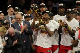 Toronto Raptors' Kawhi Leonard lifting the Larry O'Brien Championship Trophy.
