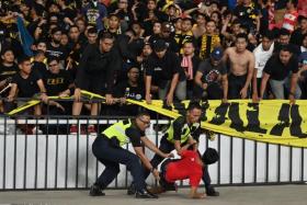 Policemen detain a supporter of Indonesia next to supporters of Malaysia (in black) after an incident during a World Cup qualifier at the Gelora Bung Karno stadium in Jakarta on Thursday (Sept 5).