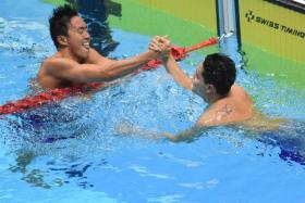 Quah Zheng Wen and Joseph Schooling congratulating each other after their close finish in the 100m butterfly final.