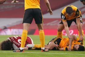Arsenal defender David Luiz and Wolverhampton Wanderers striker Raul Jimenez (in orange) on the ground after a head-on collision in an EPL game last month.