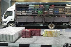 ICA officers at Tuas Checkpoint found 1,838 cartons and 703 packets of duty-unpaid cigarettes hidden in a lorry filled with fruit.
