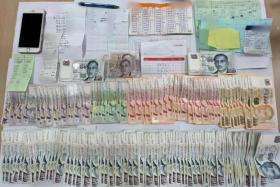 The police seized more than $30,000 in cash, an array of mobile phones, and documents such as betting records. 
