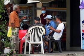 A group of men sitting about 50m away from a legal horse betting outlet in Jurong East. 