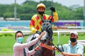 Trainer David Kok giving Win Win (Oscar Chavez astride) a pat after his grey’s last-start 53/4-length victory at Kranji on March 26. A double is on the cards.