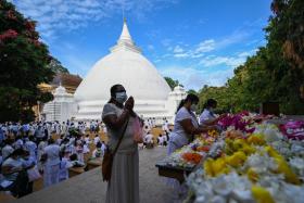 Buddhist devotees offer prayers at the Kelaniya Temple during the Vesak festival in Colombo, on May 15, 2022. 