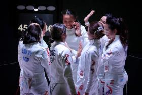 The Singapore women&#039;s epee team fencers celebrate with their Thai opponents after winning the final on May 16, 2022. 