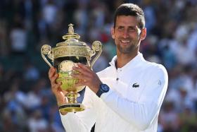 Novak Djokovic poses with the trophy, on July 10, 2022. 
