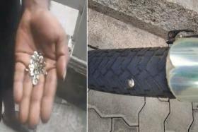 Screengrab and image from social media posts showing a person picking up a handful of thumbtacks from a pavement (left) and a thumbtack lodged in the wheel of a bicycle (right).
