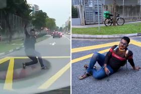 A man was caught on camera throwing himself out in front of an oncoming car before falling onto the ground even though the vehicle did not hit him.