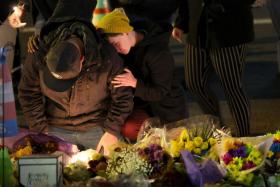 People hold a vigil at a makeshift memorial near the Club Q nightclub on Nov 20, 2022 in Colorado Springs, Colorado.