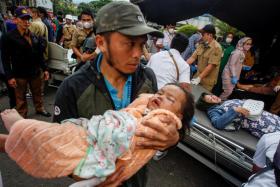 A man carries an injured child to receive treatment at a hospital, after an earthquake hit in Cianjur, West Java province, Indonesia, on Nov 21, 2022.