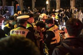 Police officers detain a man in Shanghai, China, on Sunday night, Nov. 27, 2022.