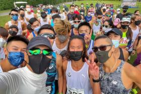 Hong Kong actor Chow Yun Fat (in white long-sleeved top and black mask) posing with other participants of the race.