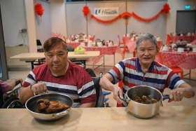 Former five-star hotel chef Francis Lim (left) and avid cook Tan Lam Huat display their dishes ahead of their reunion dinner with NTUC Health Nursing Home residents on Jan 19. 
