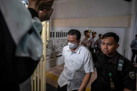 Police officer Hasdarmawan (centre) arriving for his trial at a courthouse in Surabaya, Indonesia, on March 16, 2023. PHOTO: AFP
