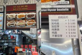 This hawker&#039;s price list indicates an additional charge of 50 cents to remove bean sprouts.
