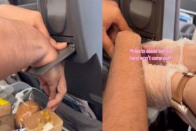 Man on flight gets hand stuck in cup holder for 10 mins; friend films his struggle